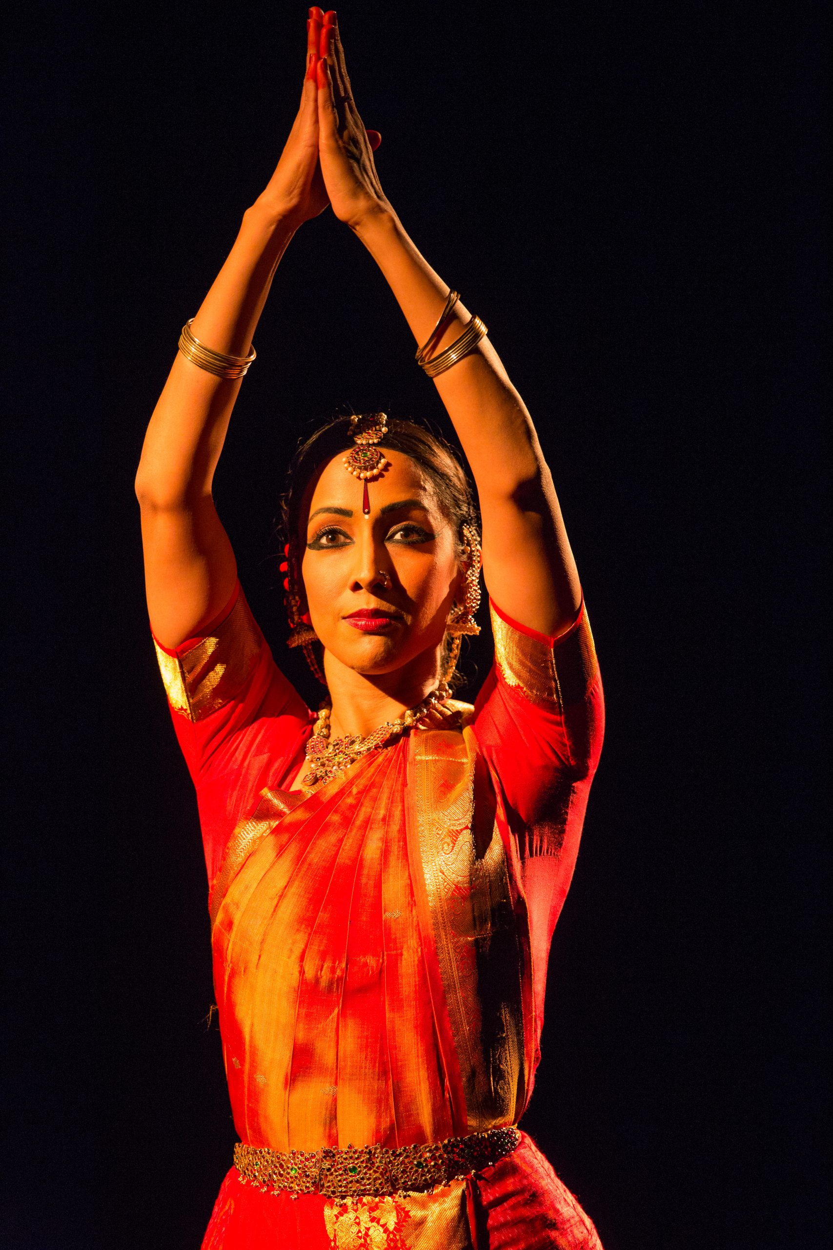 Mythili Prakash in a Bharatanatyam performance, both hands raised with expressive eyes